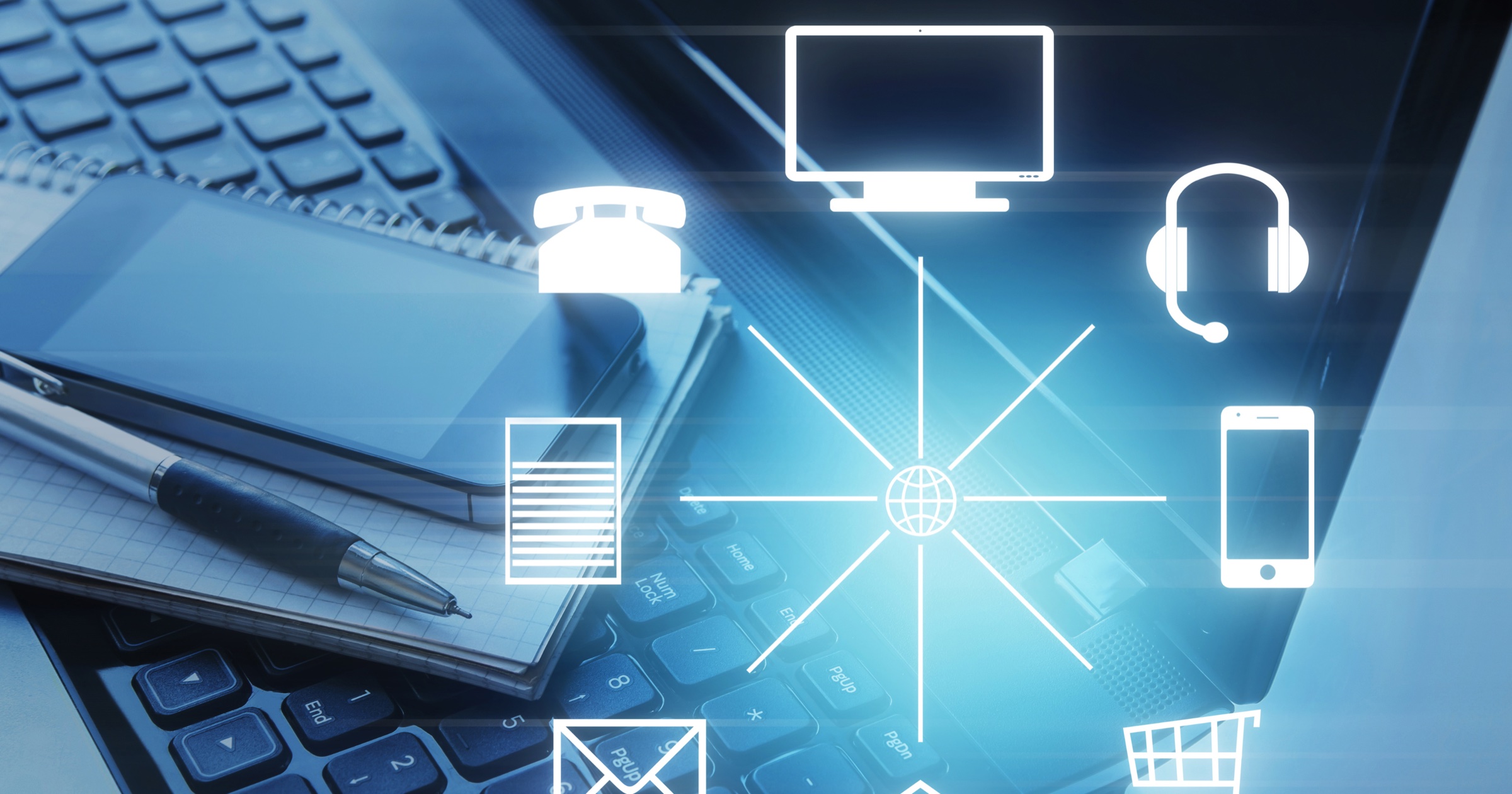 Communication and commerce icons connected over a laptop keyboard